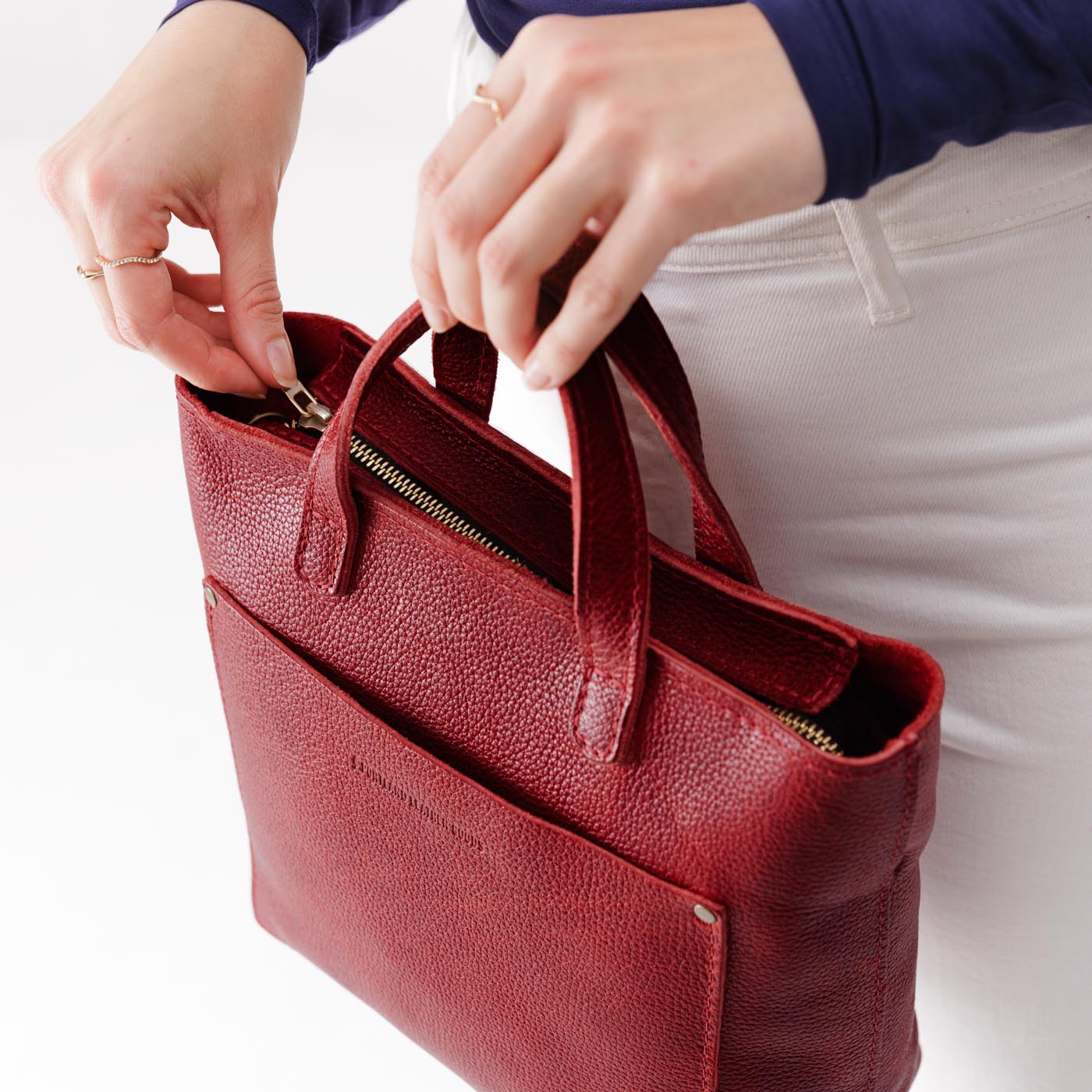Chili Red*Zipper | Model holding crossbody tote bag with zipper closure and front pocket