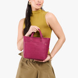 Cosmo Zipper | Model holding crossbody tote bag with zipper closure and front pocket