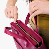 Cosmo Zipper | Model holding crossbody tote bag with zipper closure and front pocket