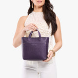 Empire Zipper | Model holding crossbody tote bag with zipper closure and front pocket