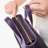 Empire Zipper | Model holding crossbody tote bag with zipper closure and front pocket