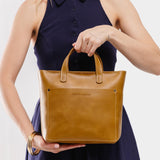 Mango Zipper | Model holding crossbody tote bag with zipper closure and front pocket