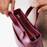 Orchid Zipper | Model holding crossbody tote bag with zipper closure and front pocket