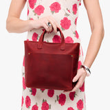 Phoenix Zipper | Model holding crossbody tote bag with zipper closure and front pocket