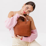 Honey Zipper | Model holding crossbody tote bag with zipper closure and front pocket