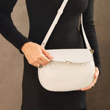 Bone Large | Model wearing a leather Crossbody with a flap and magnetic closure