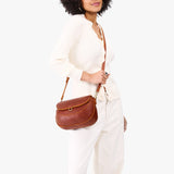 Nutmeg Large | Model wearing a leather Crossbody with a flap and magnetic closure