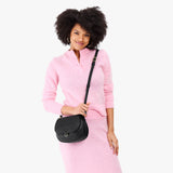 Black Small | Model wearing a petite leather Crossbody with a flap and magnetic closure