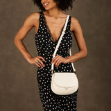 Bone Small | Model wearing a petite leather Crossbody with a flap and magnetic closure