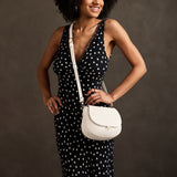 Bone Small | Model wearing a petite leather Crossbody with a flap and magnetic closure