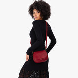 Chili Red Small | Model wearing a petite leather Crossbody with a flap and magnetic closure
