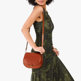Madrone Small | Model wearing a petite leather Crossbody with a flap and magnetic closure