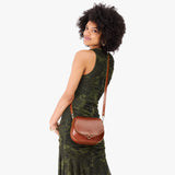 Madrone Small | Model wearing a petite leather Crossbody with a flap and magnetic closure