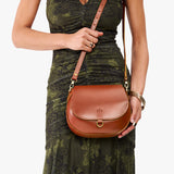 Madrone Small | Model wearing a petite leather Crossbody with a flap and magnetic closure