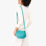 Seafoam Small | Model wearing a petite leather Crossbody with a flap and magnetic closure