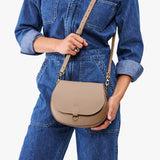 Stone Small | Model wearing a petite leather Crossbody with a flap and magnetic closure