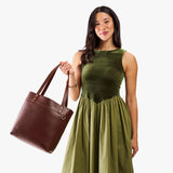 Cognac | Model wearing leather tote bag with riveted straps and exterior key loop