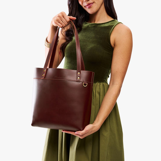 Cognac | Model wearing leather tote bag with riveted straps and exterior key loop