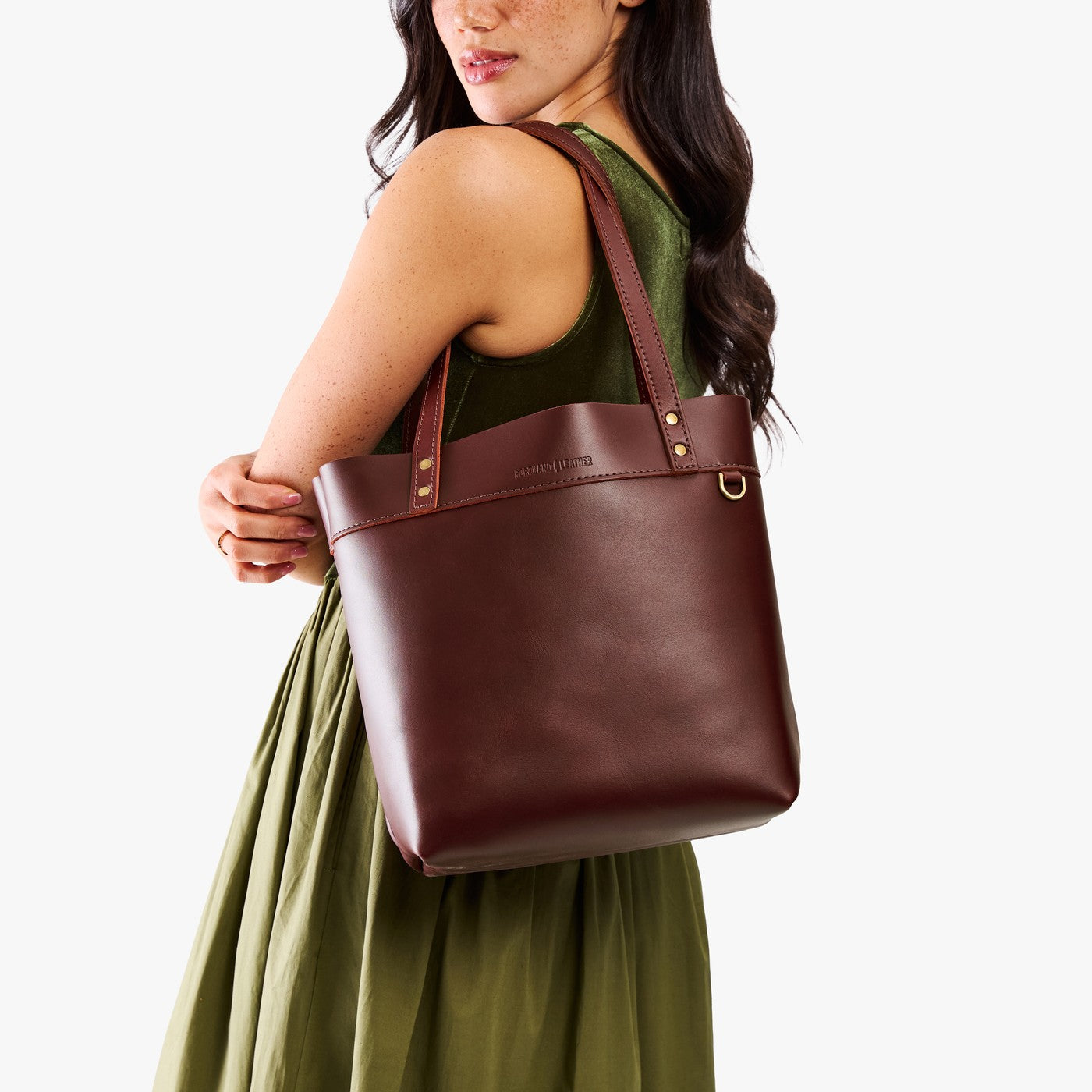 Cognac | Model wearing leather tote bag with riveted straps and exterior key loop