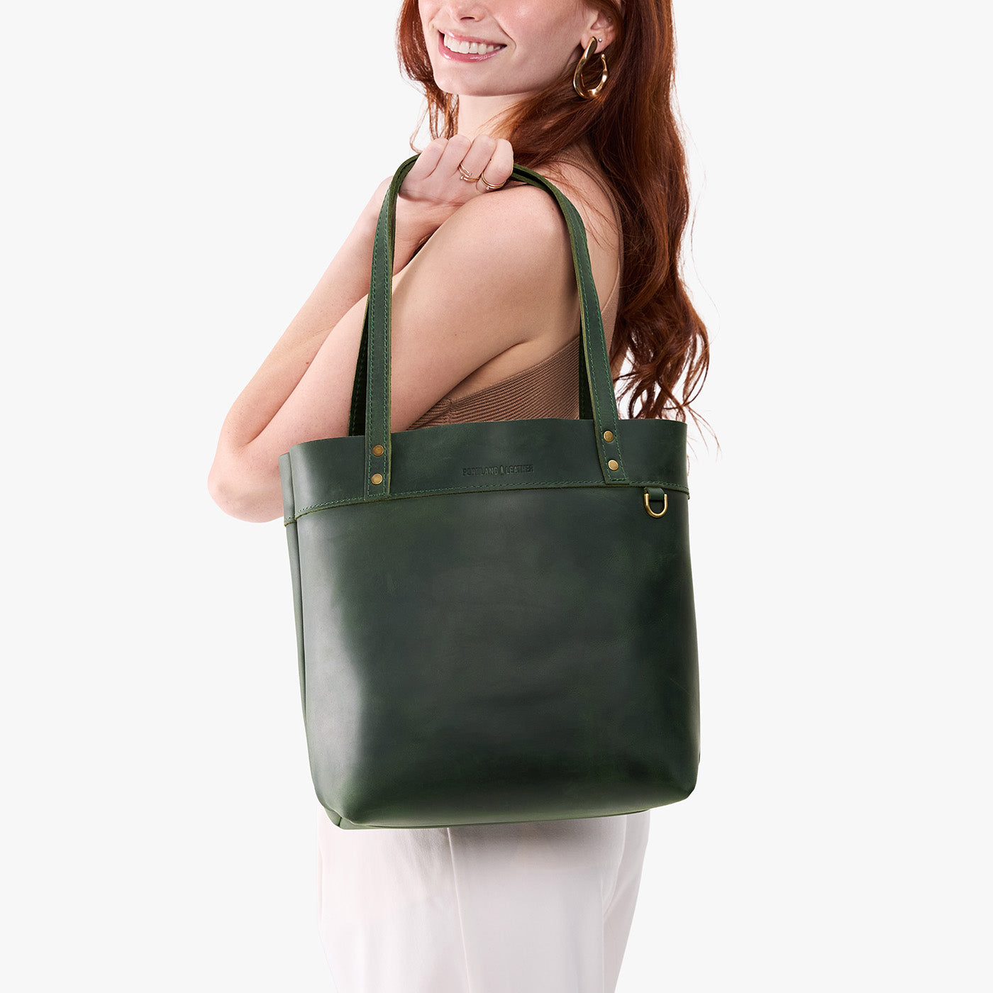 Evergreen | Model wearing leather tote bag with riveted straps and exterior key loop