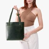 Evergreen | Model wearing leather tote bag with riveted straps and exterior key loop