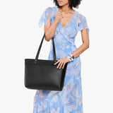 Pebbled--black Large Zipper | Model wearing leather tote bag with riveted straps and exterior key loop