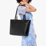 Pebbled--black Large Zipper | Model wearing leather tote bag with riveted straps and exterior key loop