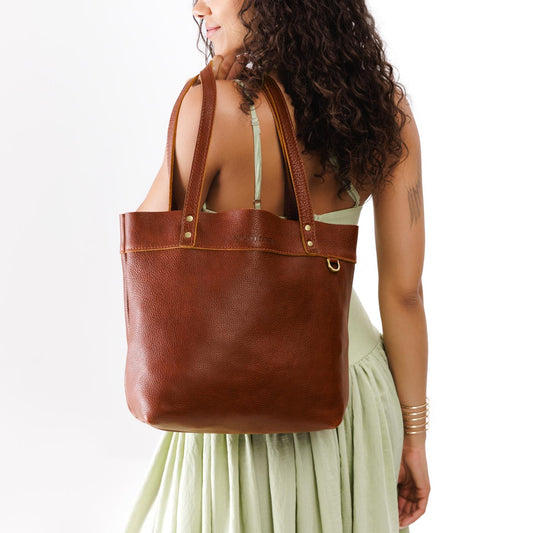 Nutmeg | Model wearing leather tote bag with riveted straps and exterior key loop