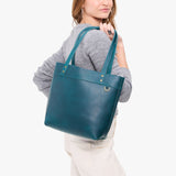 Westward Blue | Model wearing leather tote bag with riveted straps and exterior key loop