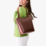 Cognac Medium Zipper | Model wearing leather tote bag with riveted straps and exterior key loop
