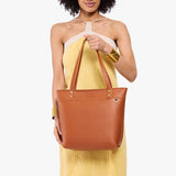 Honey Medium Zipper | Model wearing leather tote bag with riveted straps and exterior key loop