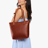 Nutmeg Medium Zipper | Model wearing leather tote bag with riveted straps and exterior key loop