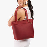 Phoenix Medium Zipper | Model wearing leather tote bag with riveted straps and exterior key loop
