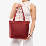 Phoenix Medium Zipper | Model wearing leather tote bag with riveted straps and exterior key loop