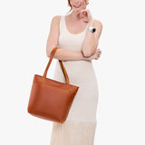 Sienna Medium Zipper | Model wearing leather tote bag with riveted straps and exterior key loop