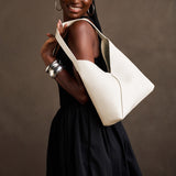 Pebbled Bone Large | Model carrying mid-size shoulder bag with magnetic snap closure