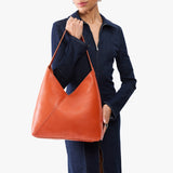Koi Oversized | Model wearing large shoulder bag with adjustable strap and magnetic snap closure