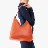 Koi Oversized | Model wearing large shoulder bag with adjustable strap and magnetic snap closure