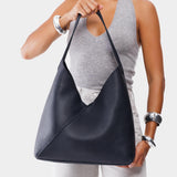 Night Owl Oversized | Model holding large shoulder bag with adjustable strap and magnetic snap closure