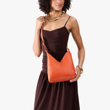 Koi Small | Model wearing petite shoulder bag with adjustable strap and magnetic snap closure