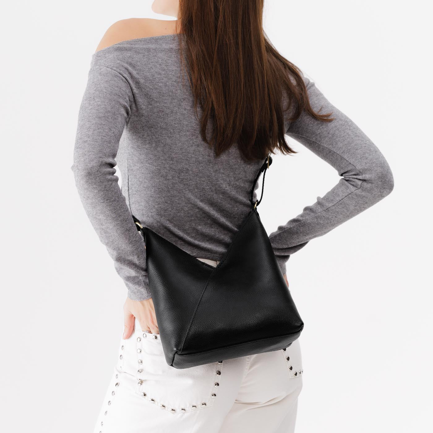 Pebbled--black*Small | Model wearing petite shoulder bag with adjustable strap and magnetic snap closure