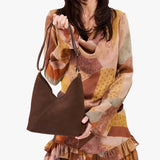 Stagecoach Small | Model holding petite shoulder bag with adjustable strap and magnetic snap closure