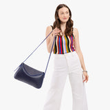 Cobalt Medium | Model wearing a leather Crossbody with a flap and magnetic closure