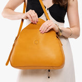 Sunshine Medium | Model wearing a leather Crossbody with a flap and magnetic closure