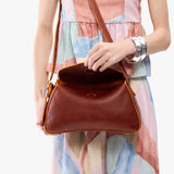 Nutmeg Small | Model wearing a leather Crossbody with a flap and magnetic closure