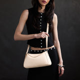 Pebbled Bone Small | Model wearing a leather Crossbody with a flap and magnetic closure