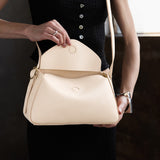 Pebbled Bone Small | Model wearing a leather Crossbody with a flap and magnetic closure