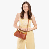 Sienna Small | Model wearing a leather Crossbody with a flap and magnetic closure