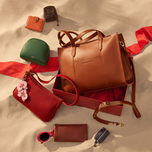 Group of leather mystery box items containing a bags, wallets and pouches on sand