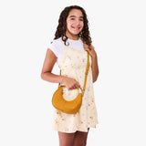 Sunshine | Model with a crescent shaped shoulder bag with zipper closure and gold accents